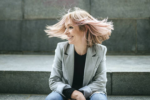 Happy woman moving her pink hair stock photo