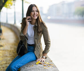 Junge brünette Frau mit Smartphone in Verona, Italien - GIOF07729