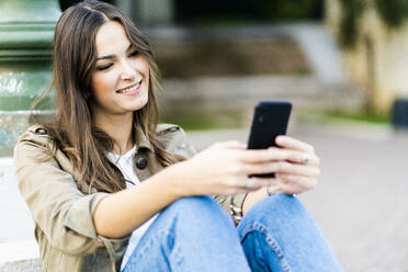 Young brunette woman using smartphone in Verona, Italy - GIOF07732