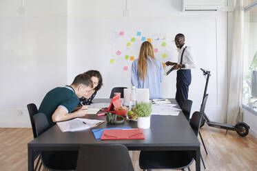 Junge Geschäftsleute bei einer Besprechung in einem modernen Büro - IGGF01448