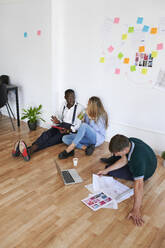 Young business people sitting together in an office having a meeting - IGGF01462