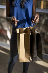 Female Afro-American with shopping bags in a mall - MAUF03057