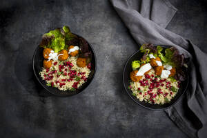 Schalen mit Falafel, Salat, Joghurt, Granatapfelkernen, Petersilie, Minze und Tabbouleh-Salat - LVF08431