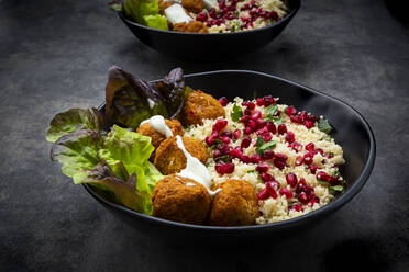 Bowls of falafel with lettuce, yogurt, pomegranate seeds, parsley, mint and Tabbouleh salad - LVF08432