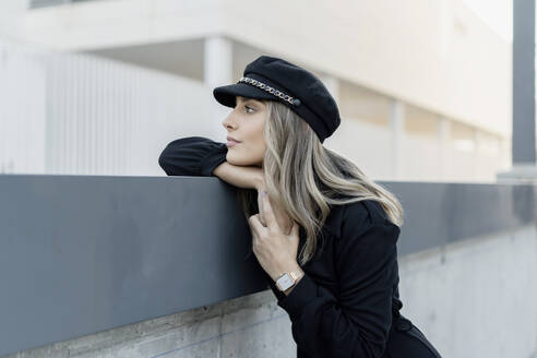 Junge blonde Geschäftsfrau mit schwarzer Matrosenmütze und Blick zur Seite - ERRF02102