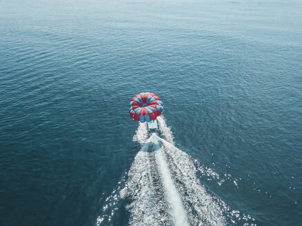 Indonesien, Bali, Nusa Dua, Luftaufnahme von Person Parasailing und Motorboot - KNTF03714