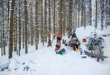 Austria, Salzburg, Altenmarkt im Pongau, Winter sports equipment lying in front of snow-covered forest hut - HHF05573
