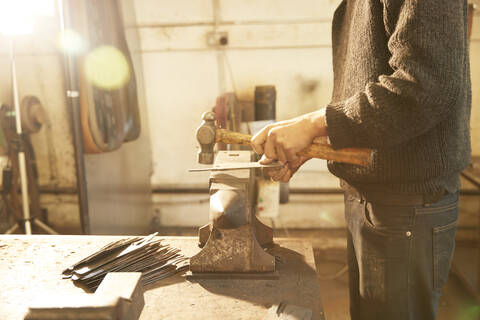 Man making knives in a workshop stock photo