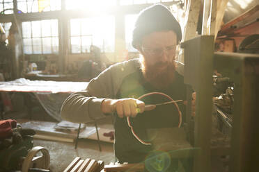 Mann fertigt Messer in einer Werkstatt - PMF00895