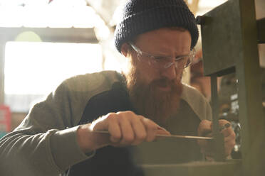 Mann fertigt Messer in einer Werkstatt - PMF00896