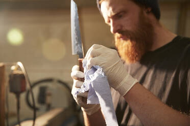 Mann fertigt Messer in einer Werkstatt - PMF00906