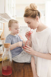 Mother with her little boy drinking a glass of juice - EYAF00678