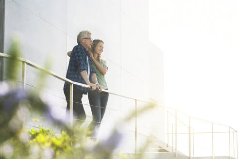 Smiling couple standing in front of their modern home - SBOF02055