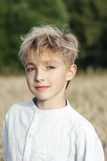 Porträt eines blonden Jungen in einem Haferfeld - EYAF00704