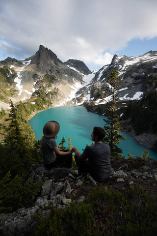 Ein Paar genießt die Aussicht auf den Alpine Blue Lake, Washington, USA, lizenzfreies Stockfoto