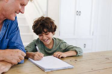 Vater hilft Sohn bei den Hausaufgaben zu Hause - ISF22720