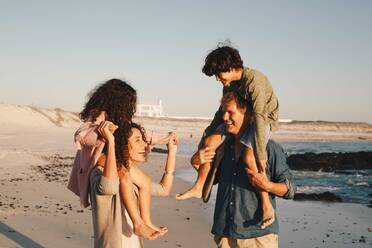 Ehepaar nimmt Kinder am Strand huckepack - ISF22774