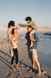 Kinder nehmen ihre Eltern am Strand huckepack - ISF22775