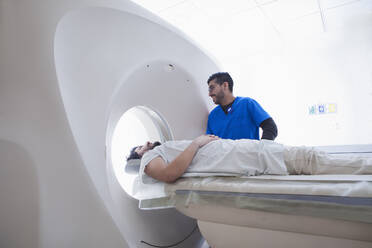 Junger männlicher Röntgenassistent bei der Bedienung eines CT-Scanners in der radiologischen Abteilung - ISF22793