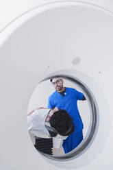 Junger männlicher Röntgenassistent bei der Bedienung eines CT-Scanners in der radiologischen Abteilung - ISF22794