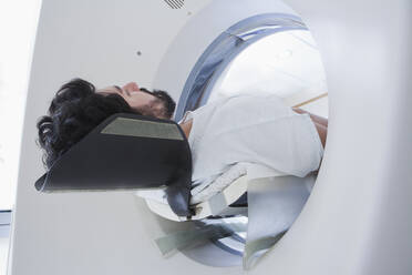Junger männlicher Patient bei einer CT-Untersuchung in der radiologischen Abteilung, von unten gesehen - ISF22796