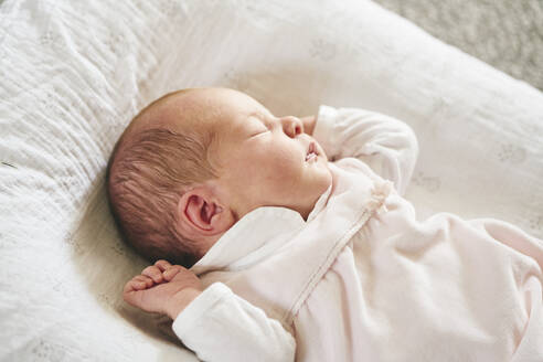 Baby schläft auf U-förmigem Kissen zu Hause - CUF53233