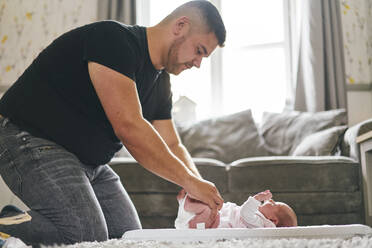 Father changing baby's diaper at home - CUF53248