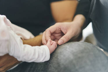 Baby hält den Finger der Mutter - CUF53262