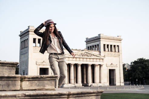 Fröhliche junge Frau auf der Treppe am Königsplatz, München, Deutschland - WFF00169