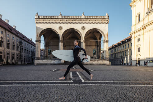 Junge Frau mit Surfbrett auf dem Weg nach Eisbach, München, Deutschland - WFF00193