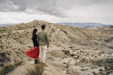 Junges Paar in Wüstenlandschaft unter bewölktem Himmel, Almeria, Andalusien, Spanien - MPPF00244