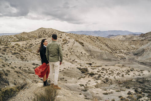 Junges Paar in Wüstenlandschaft unter bewölktem Himmel, Almeria, Andalusien, Spanien - MPPF00245