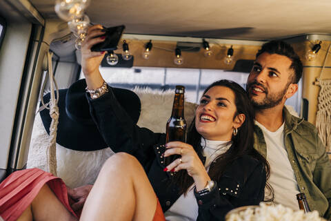 Glückliches junges Paar macht ein Selfie im Wohnmobil, lizenzfreies Stockfoto