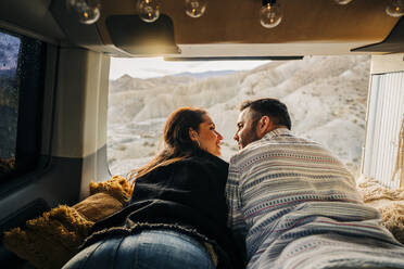 Young couple on a trip lying in a camper van at sunset, Almeria, Andalusia, Spain - MPPF00266