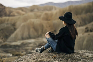Junge Frau sitzt in Wüstenlandschaft, Almeria, Andalusien, Spanien - MPPF00269