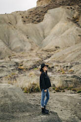 Young woman standing in desert landscape, Almeria, Andalusia, Spain - MPPF00274