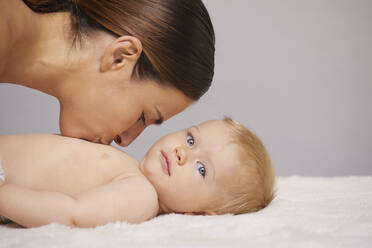 Mother kissing baby on chest - CUF53406