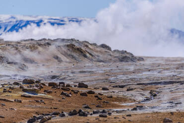 Barren landscape with steam rising beyond rocks, Akureyri, Eyjafjardarsysla, Iceland - CUF53480