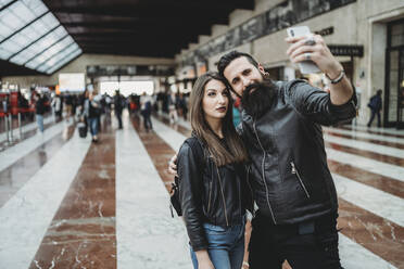 Pärchen macht Selfie mit Smartphone im Bahnhof - CUF53495