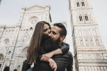 Paar beim Huckepackfahren und Küssen, Santa Maria del Fiore, Florenz, Toskana, Italien - CUF53501