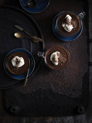 Rustic low key still life with coffee, chocolate truffle cups on table, overhead view - ISF22893