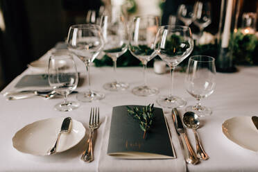 Gedeckter Tisch für die Hochzeitsfeier mit Besteck, Speisekarte und Trinkgläsern - ISF22936