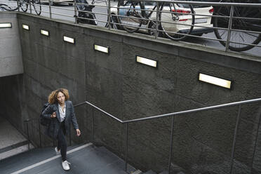 Woman walking up dtairs at a subway station, Berlin, Germany - AHSF01287