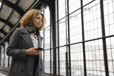 Woman with cell phone waiting in subway station - AHSF01303