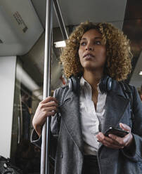 Woman with smartphone on a subway - AHSF01306