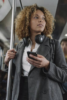 Frau mit Smartphone in einer U-Bahn - AHSF01309
