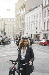 Frau mit Fahrrad in der Stadt, Berlin, Deutschland - AHSF01313