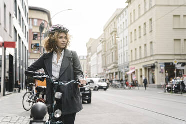 Frau mit Fahrrad in der Stadt, Berlin, Deutschland - AHSF01315