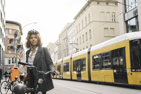 Frau mit Fahrrad in der Stadt, Berlin, Deutschland - AHSF01316