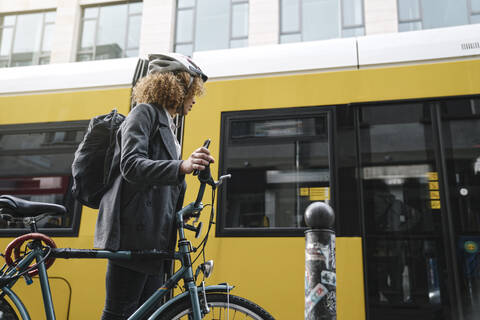 Woman commuting with a bicycle in the city, Berlin, Germany stock photo